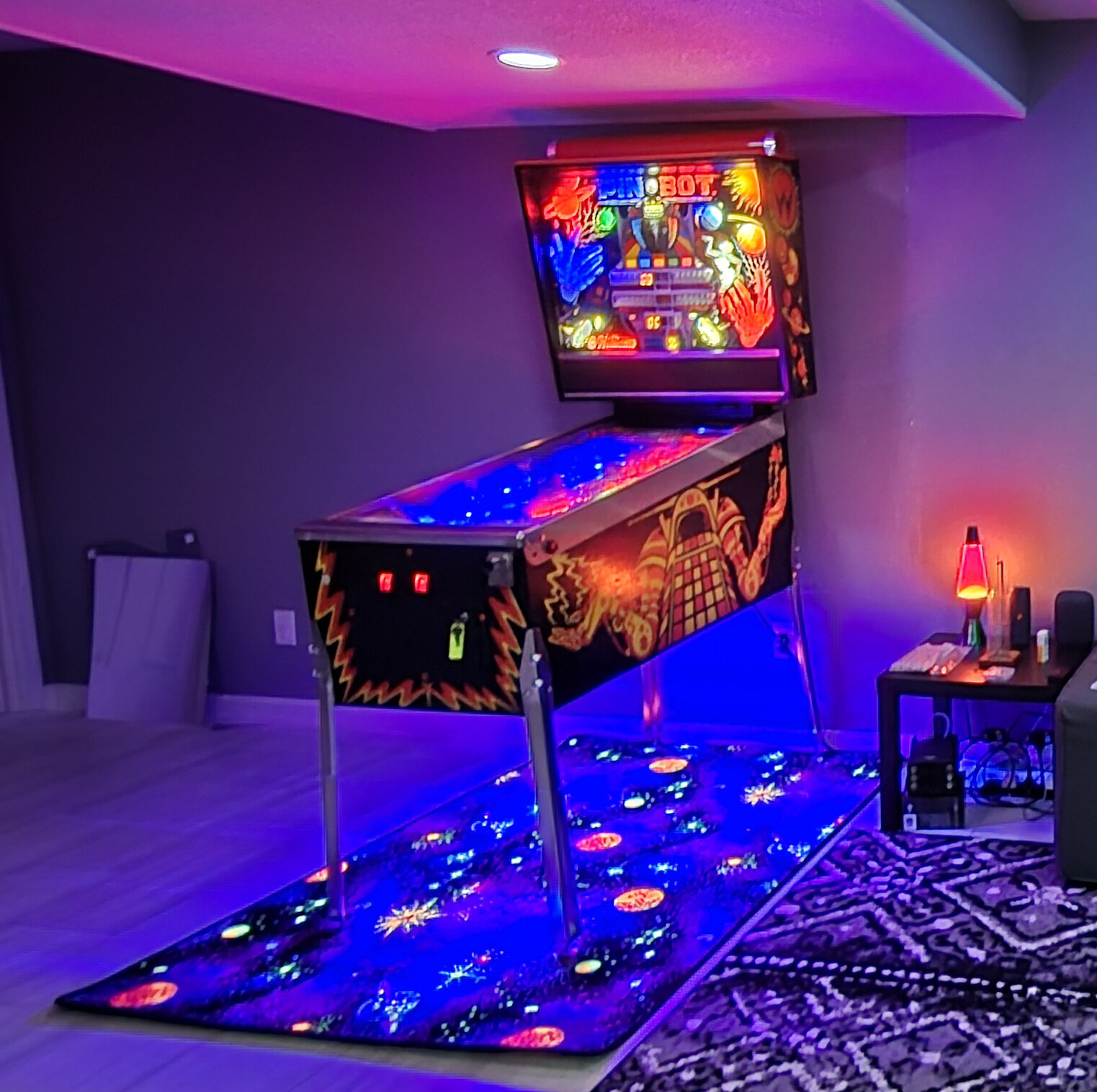 James’s Williams Pin·Bot pinball machine lit up in a game room